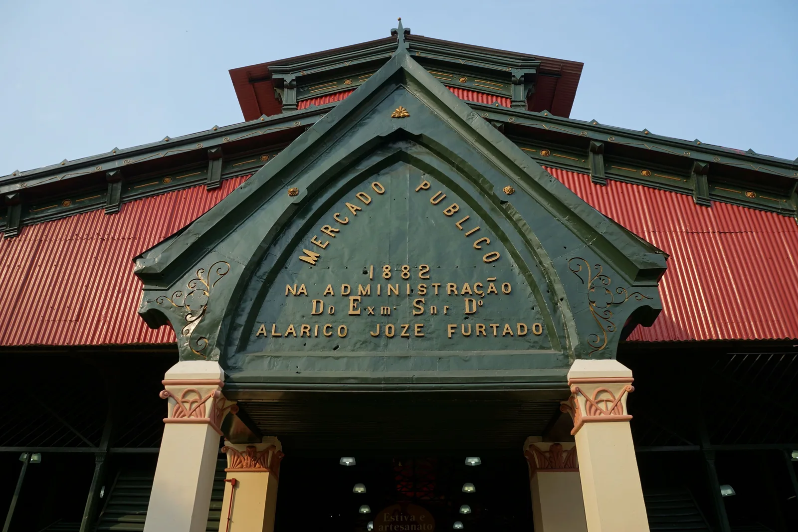 The green painted iron gable over the entrance of the Manaus municipal market, lettered MERCADO PUBLICO and dated 1882 in gold