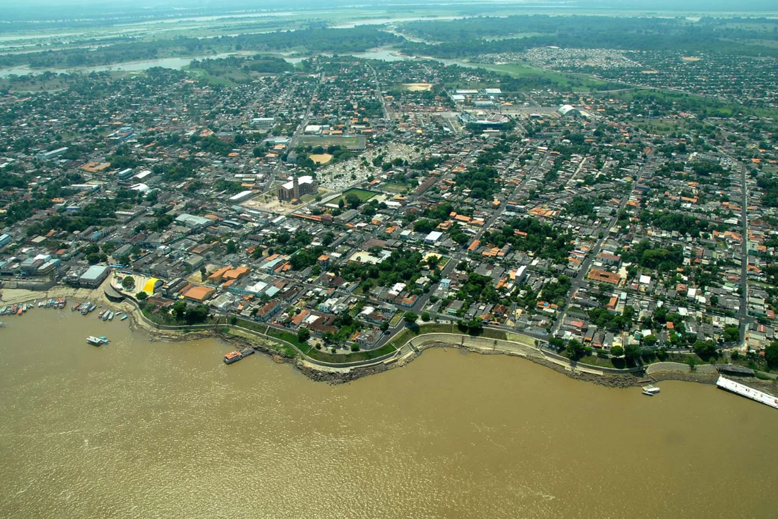The town of Parintins from the air, laid out along a bend of the river with the forest closing in behind it