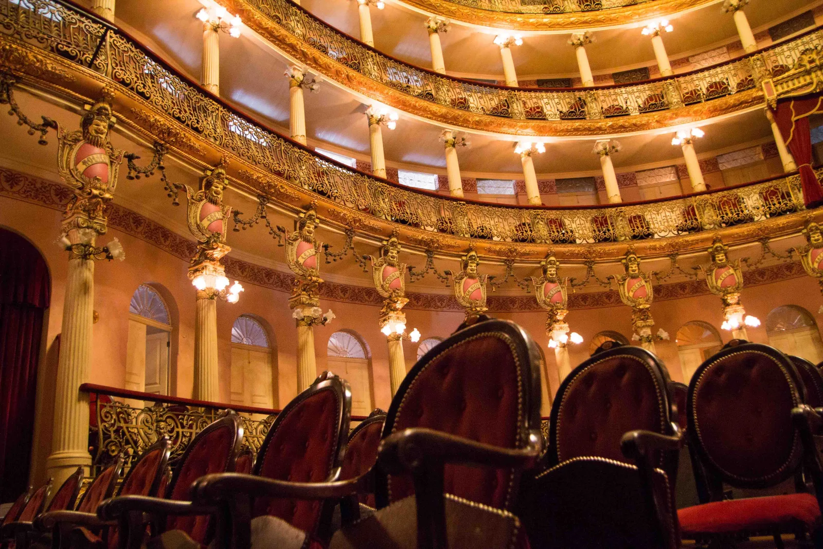 Tiers of boxes inside the Teatro Amazonas, red velvet chairs behind gilded balconies