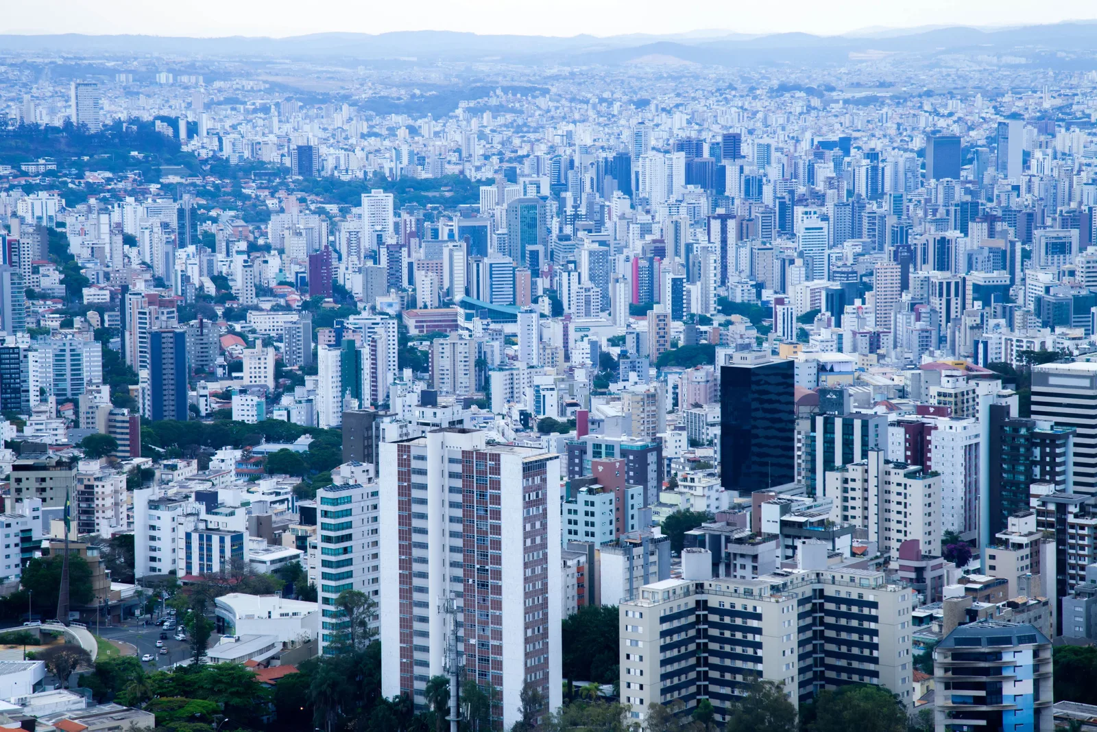 Belo Horizonte from above: a dense spread of white and gray apartment towers running to green hills on the horizon