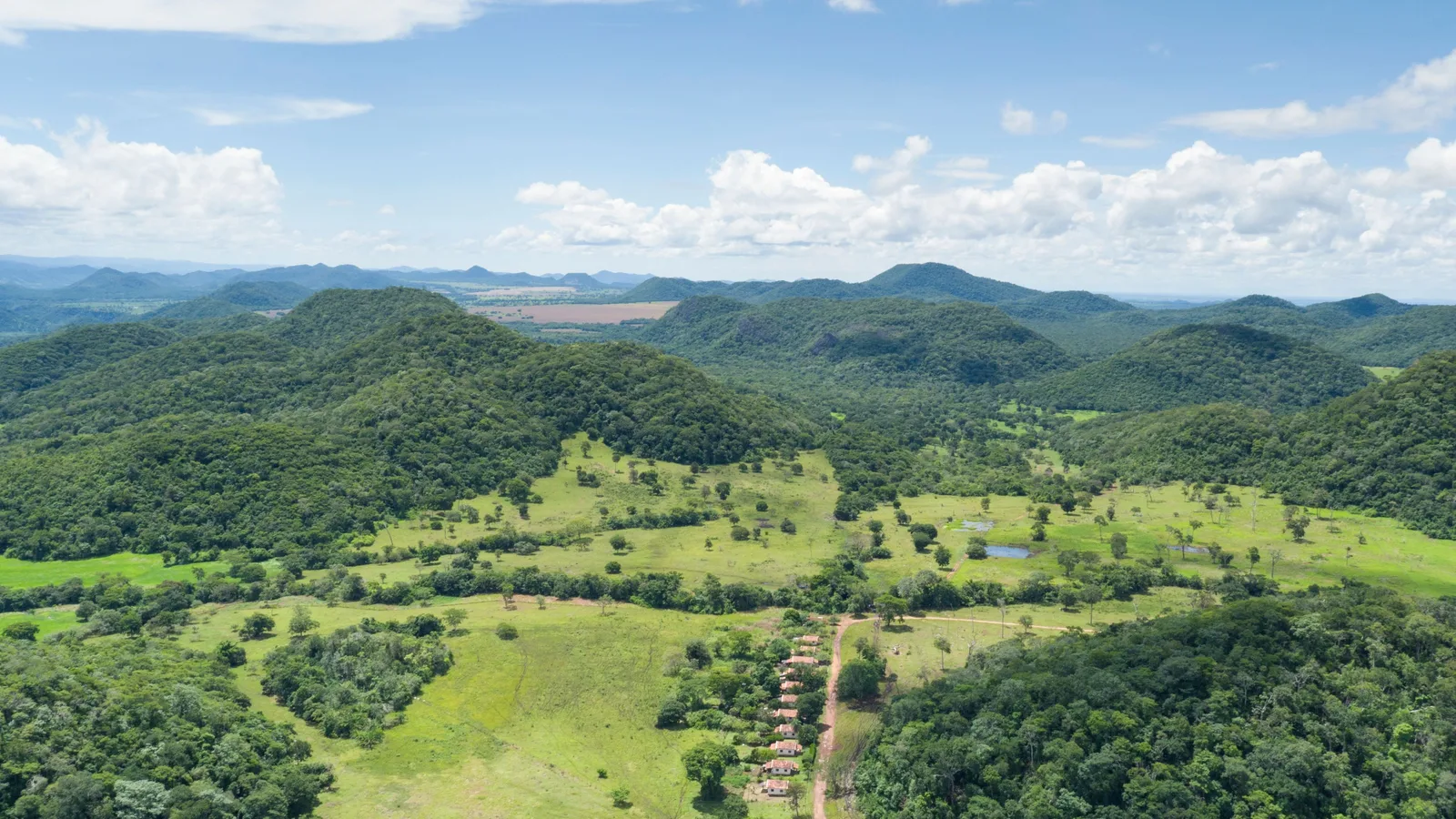 Rolling green pasture and patches of forest running back to the low wooded ridges of the Serra da Bodoquena under a bright sky
