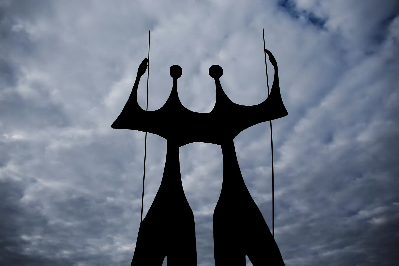 Bruno Giorgi’s bronze sculpture Os Guerreiros, known as Os Candangos, two tall elongated figures standing against a cloudy sky in the Praça dos Três Poderes