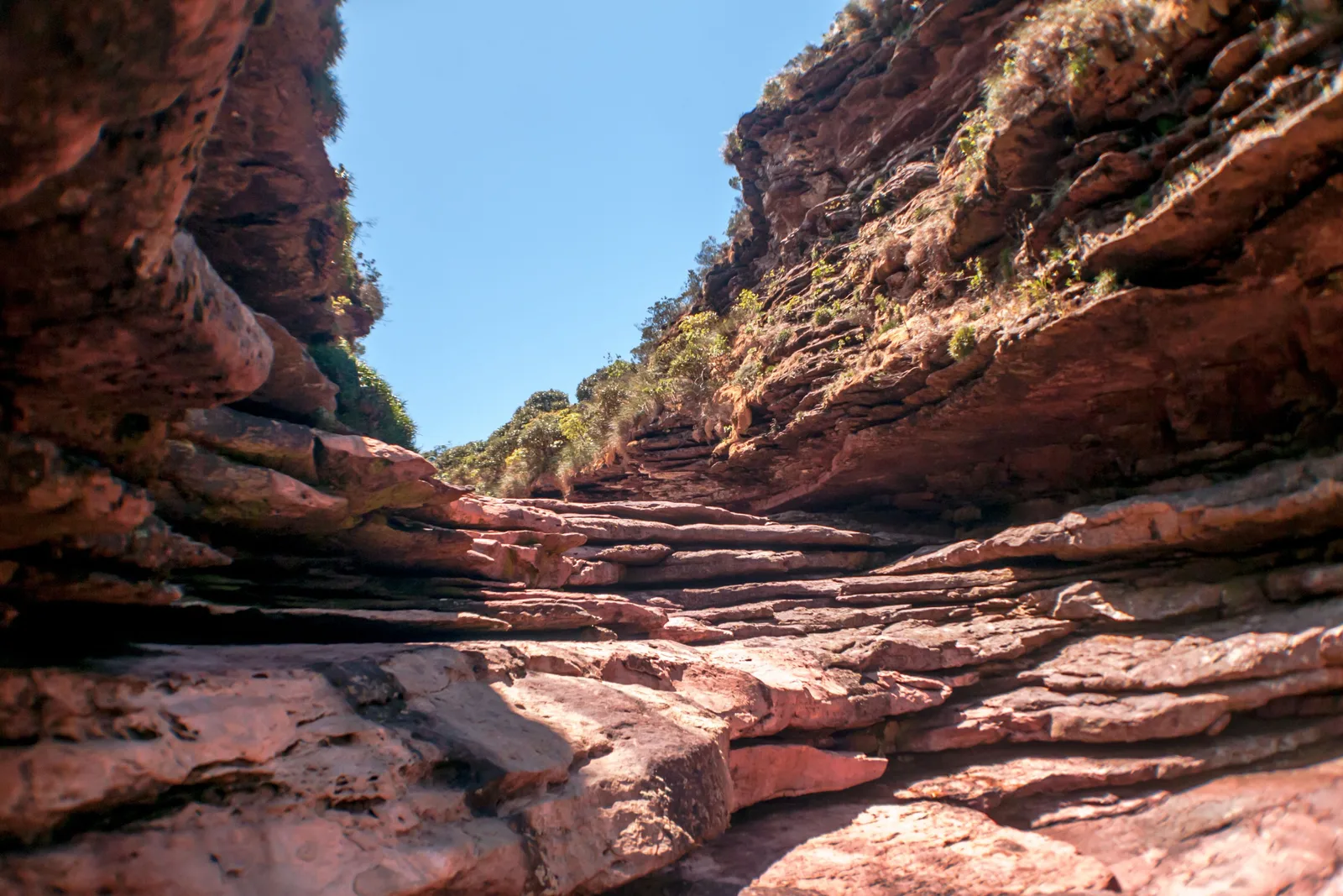 The bare banded-rock channel at the lip of Cachoeira da Fumaça in the dry season, with no water running through it