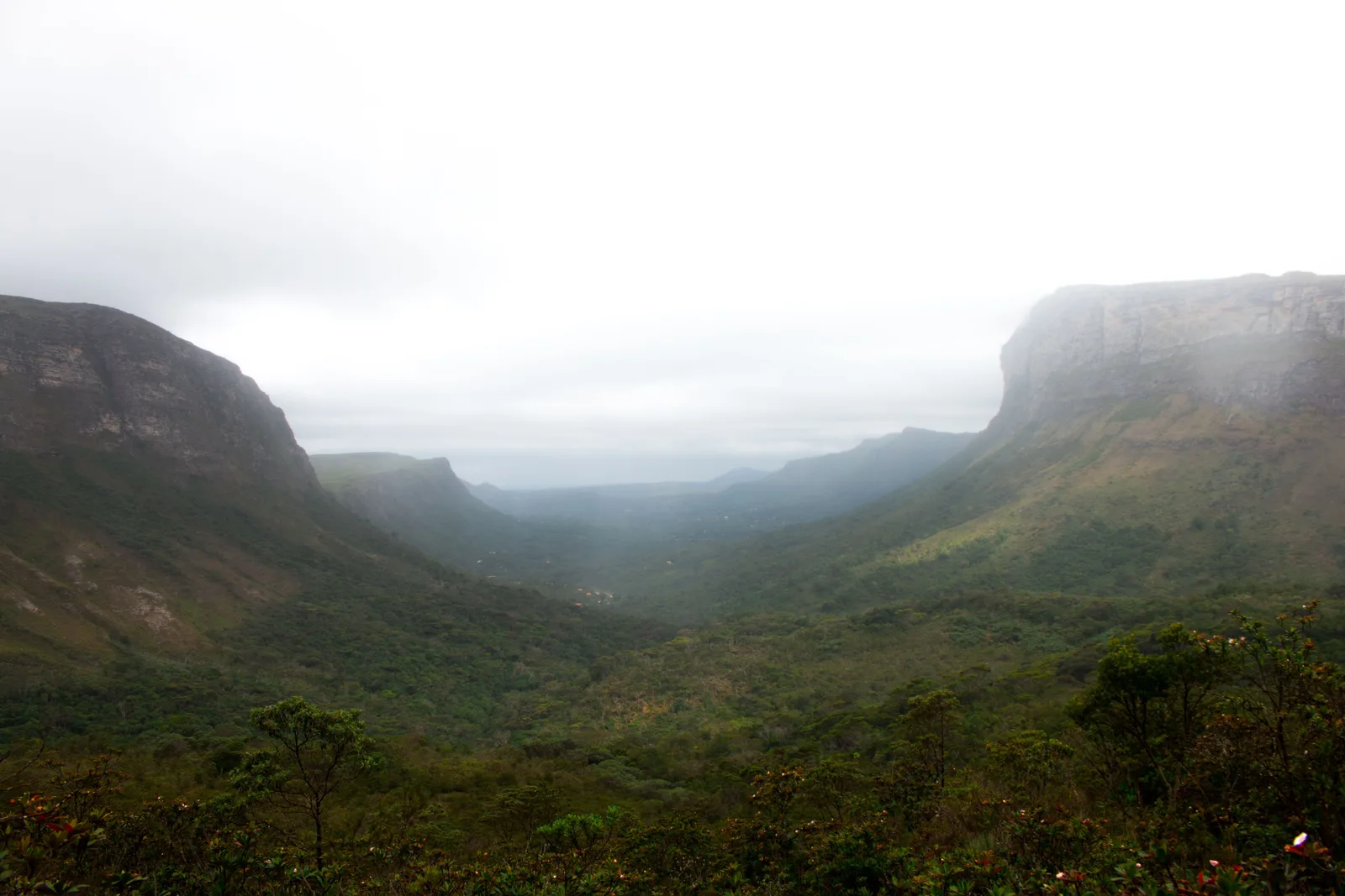 Low cloud lying along a broad valley floor between two long escarpments