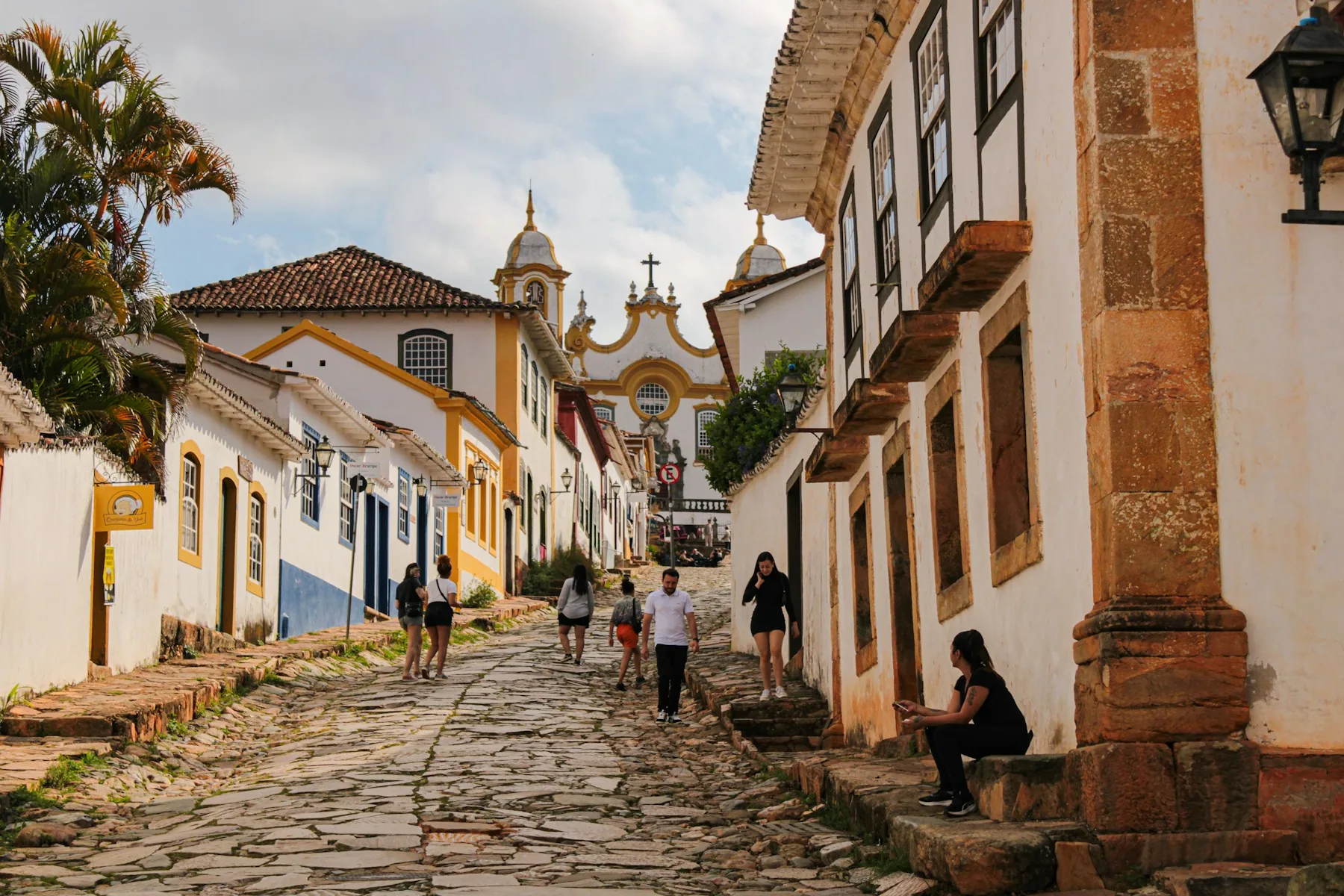 A cobbled street of pastel colonial houses in a historic town center
