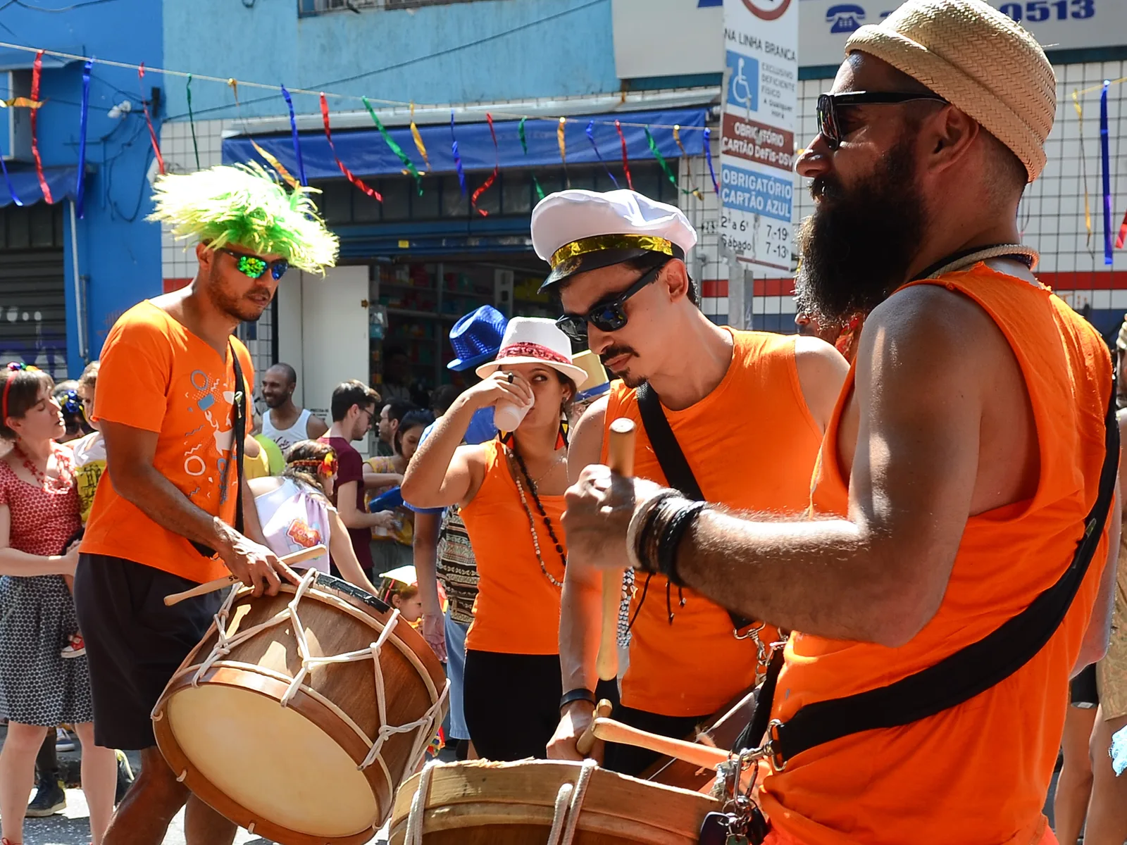 A Carnaval street bloco: drummers and a costumed crowd filling a decorated street