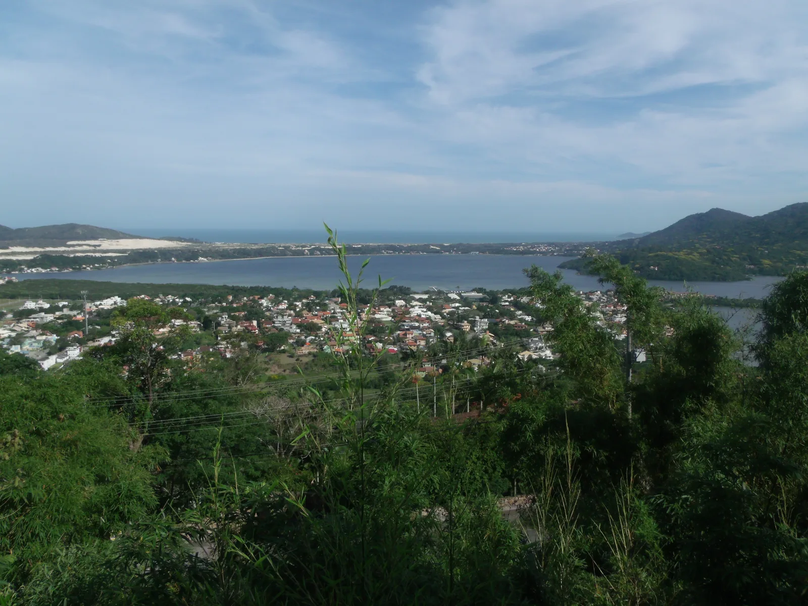 Elevated view over the Lagoa da Conceição lagoon, the town along its shore, dunes and ocean beyond