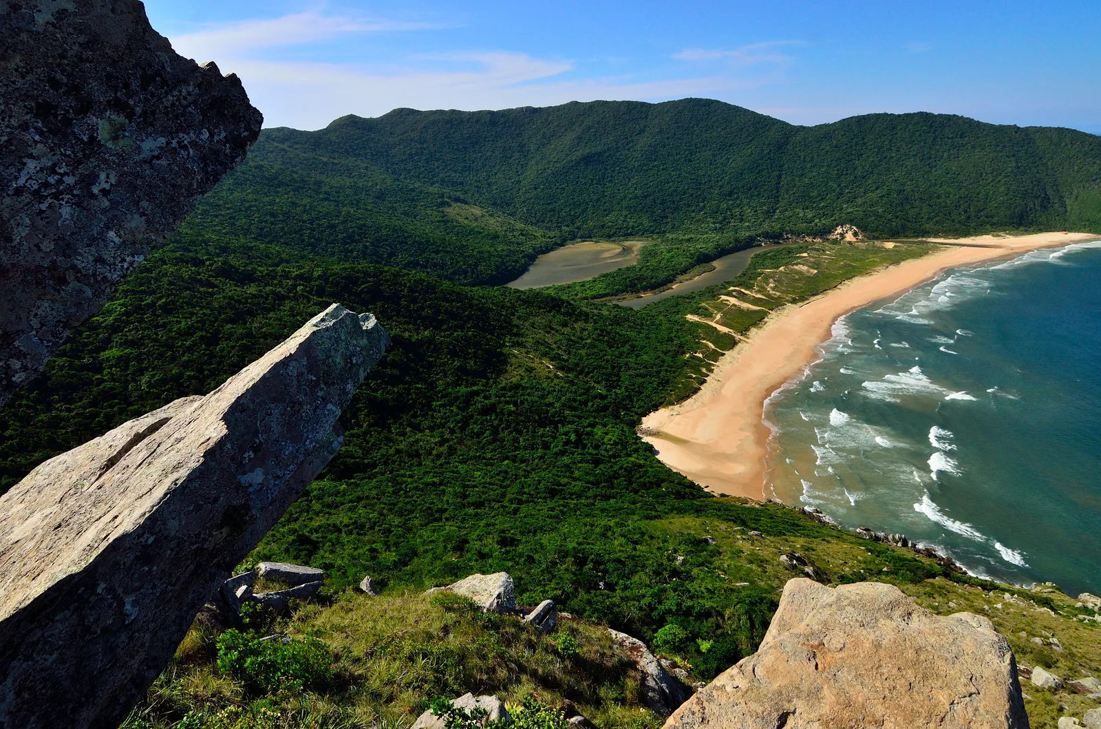 A jutting rock ledge overlooking Lagoinha do Leste’s beach and lagoon from high on the ridge trail