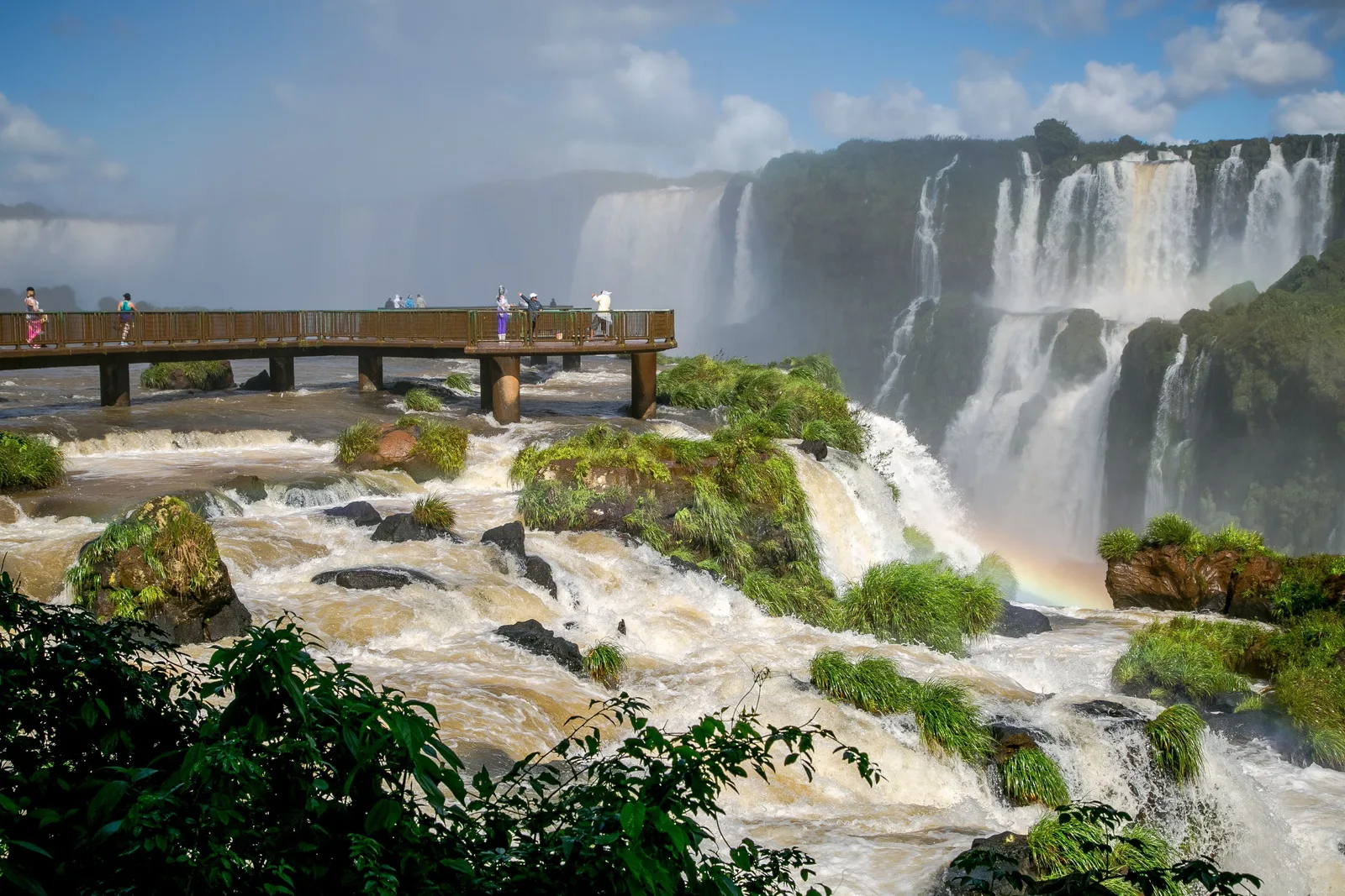 The catwalk on the Brazilian side running out below the falls, a rainbow in the spray