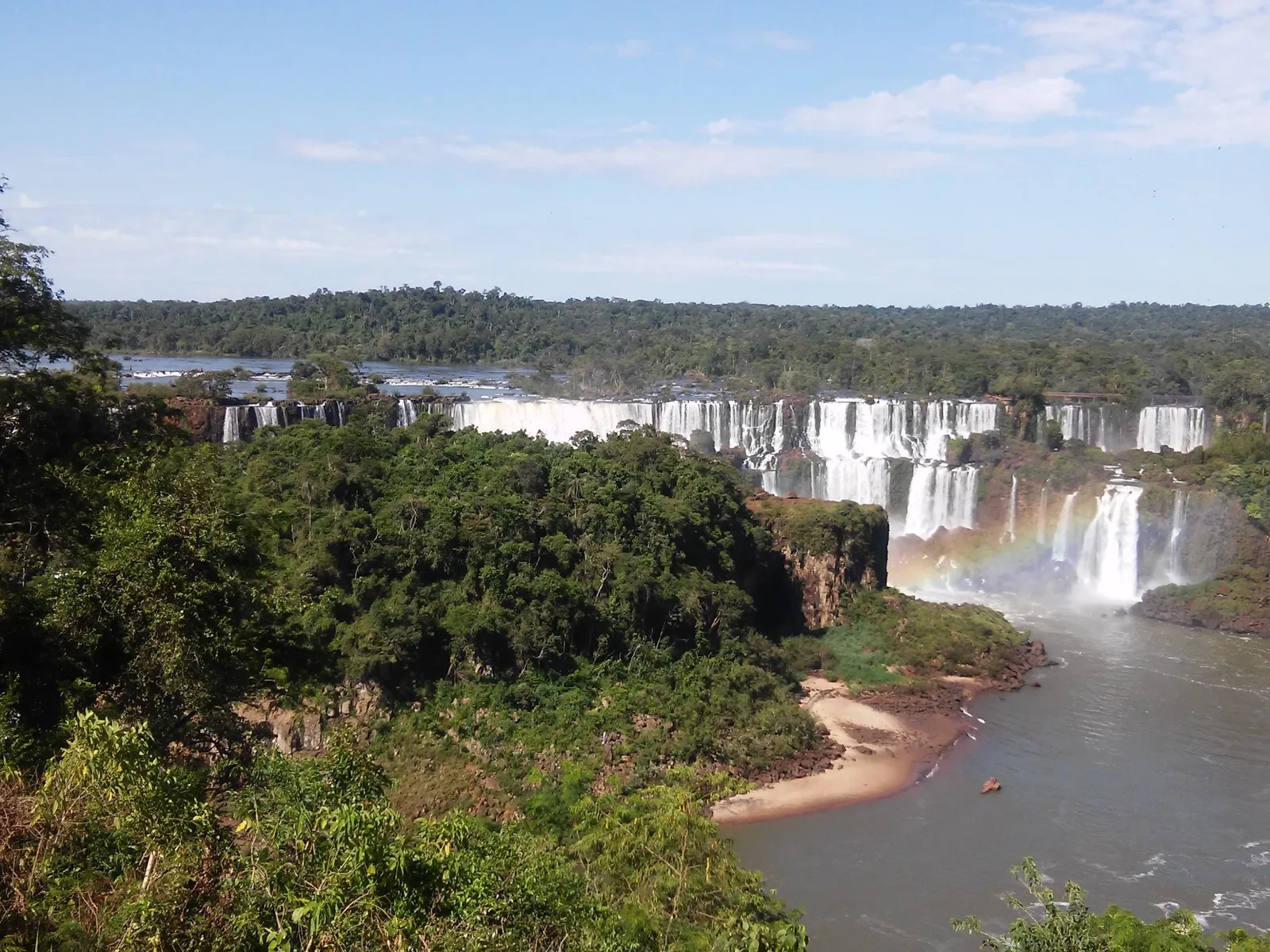 The line of falls seen across the gorge from the Brazilian trail, the river running below and forest closing in on both banks