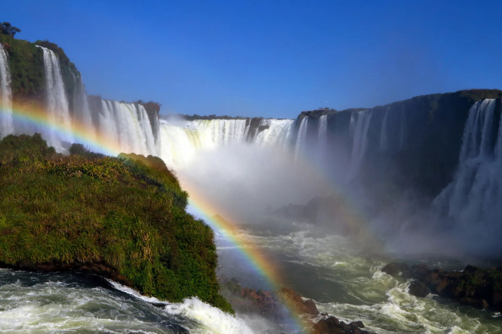 A rainbow over Iguaçu Falls at sunset