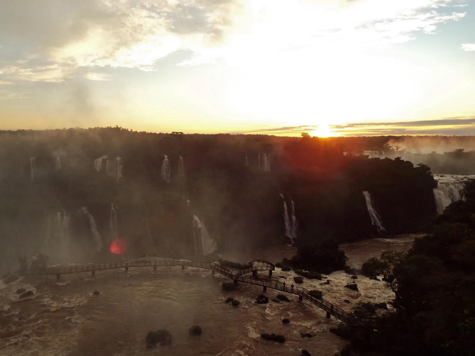The sun going down over the falls, the gorge already in shadow and the last light coming through the spray