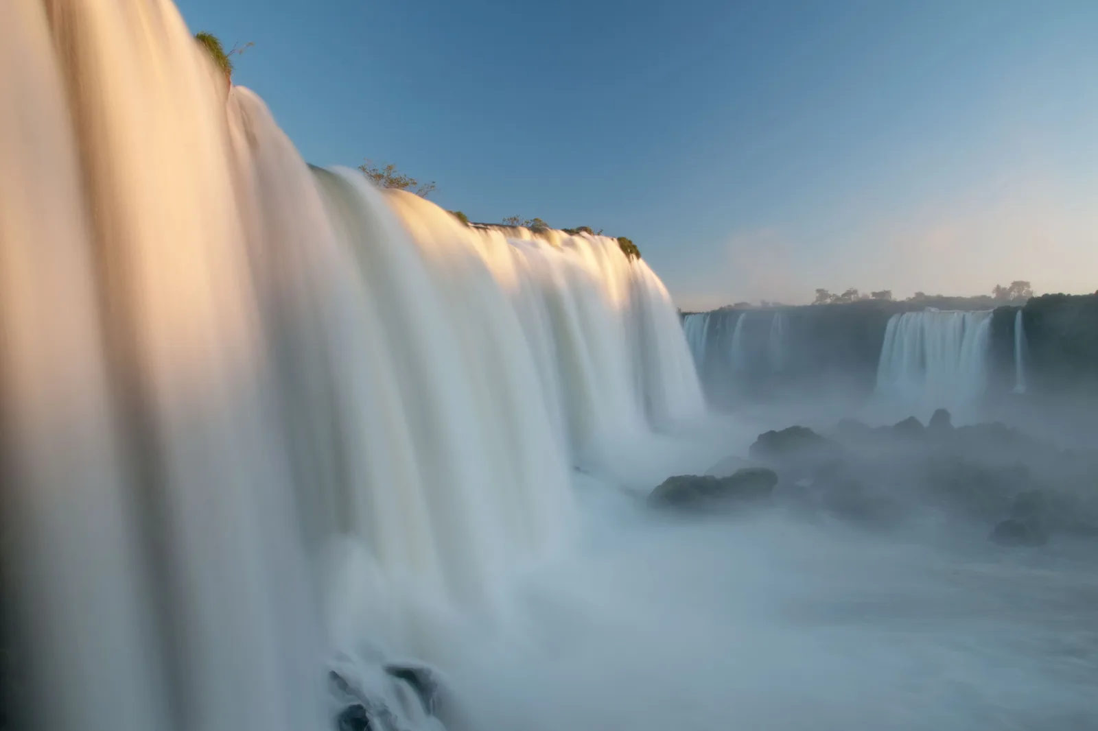 The falls at dusk, the water blurred smooth in a long exposure under a pale sky
