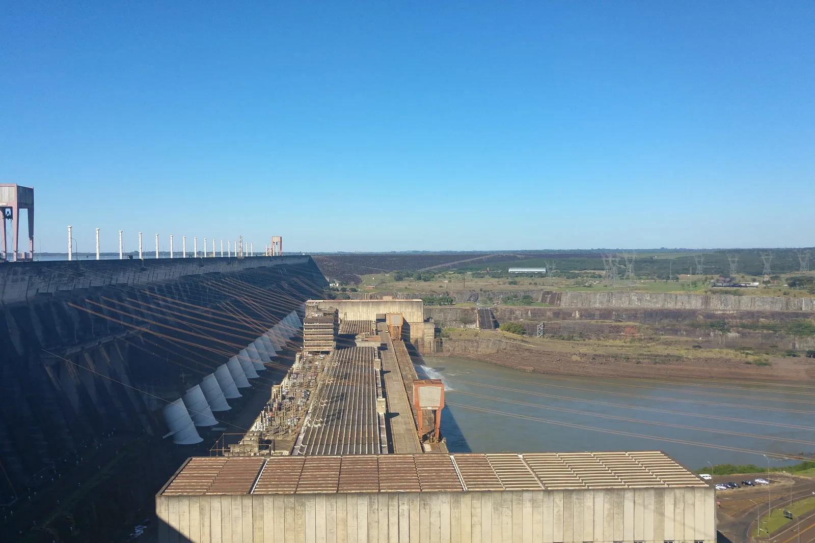The crest of the Itaipu dam looking along its length, the reservoir on one side and the drop to the powerhouse on the other