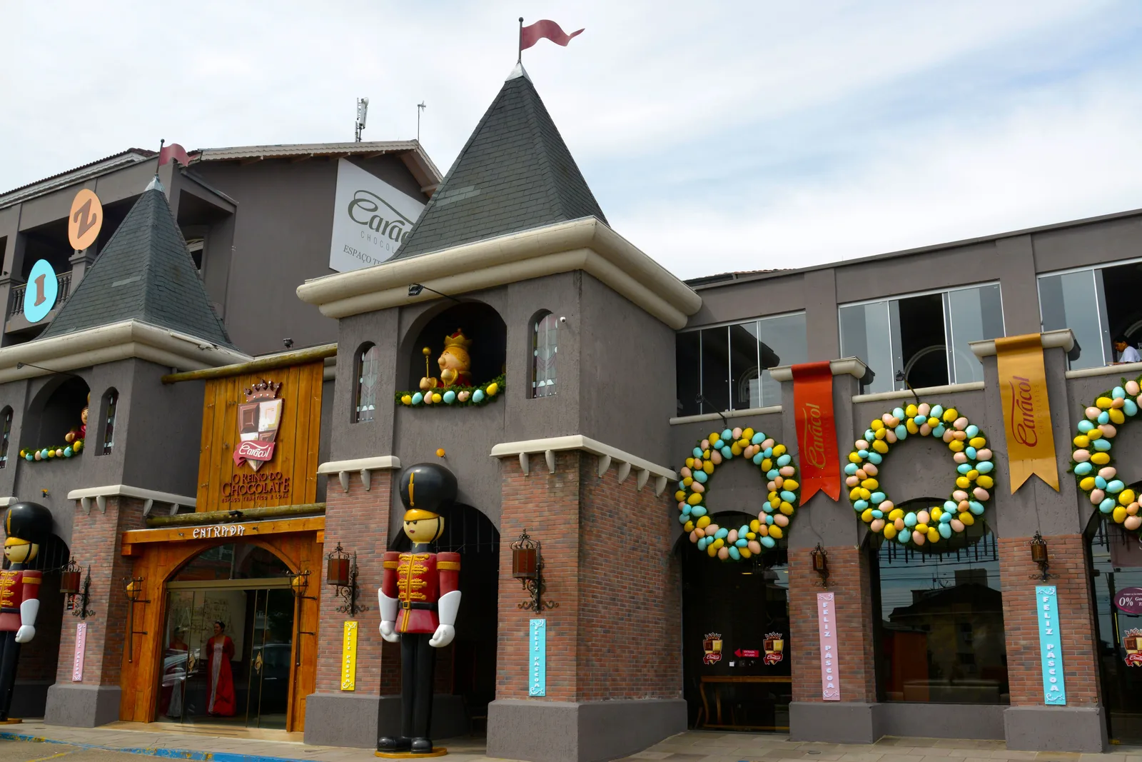 The Reino do Chocolate in Gramado, built to look like a castle, with gray turrets, giant toy-soldier figures at the doors and wreaths of colored Easter eggs on the front