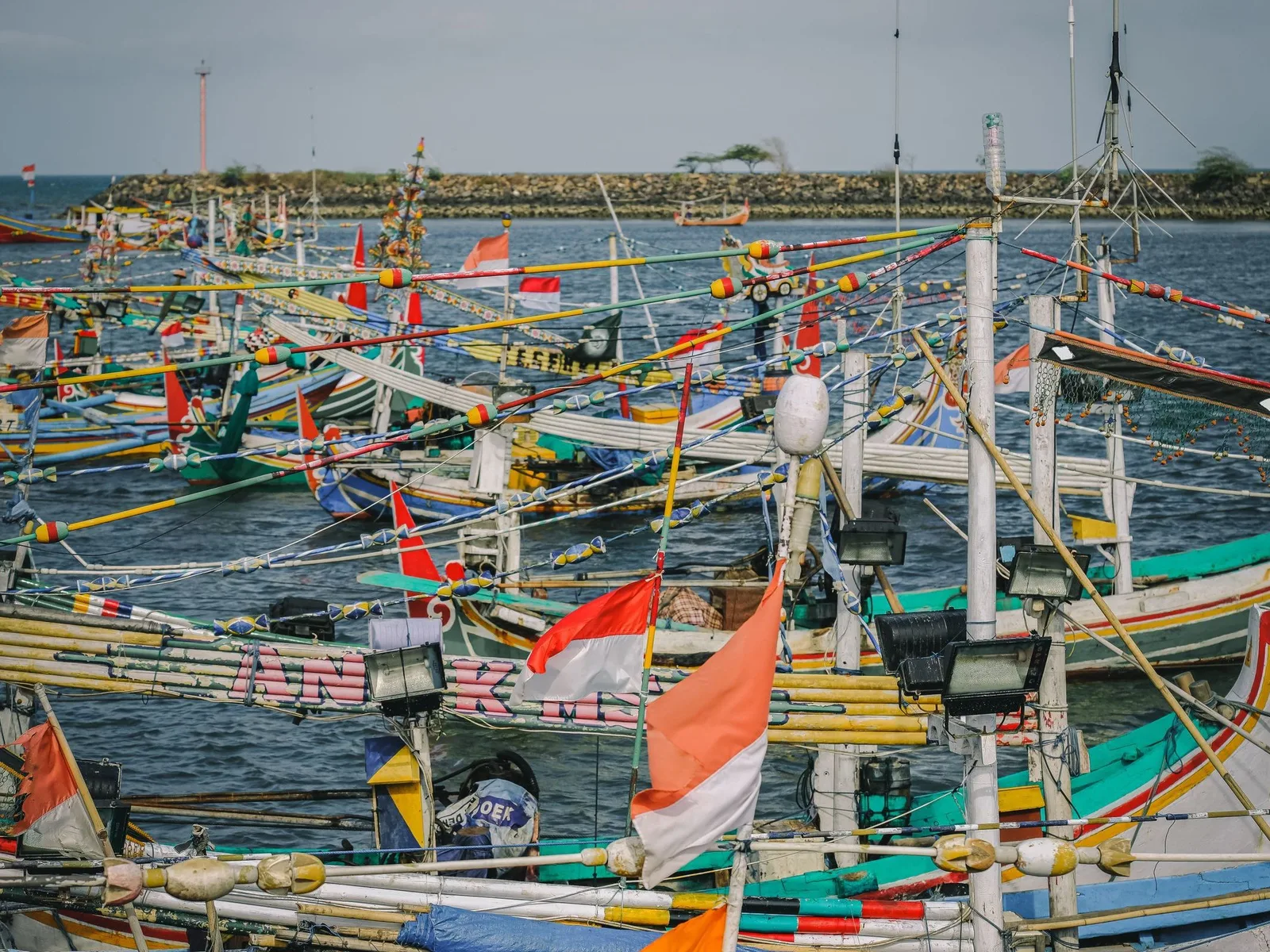 Wooden fishing boats decorated with flags and bunting, moored close together