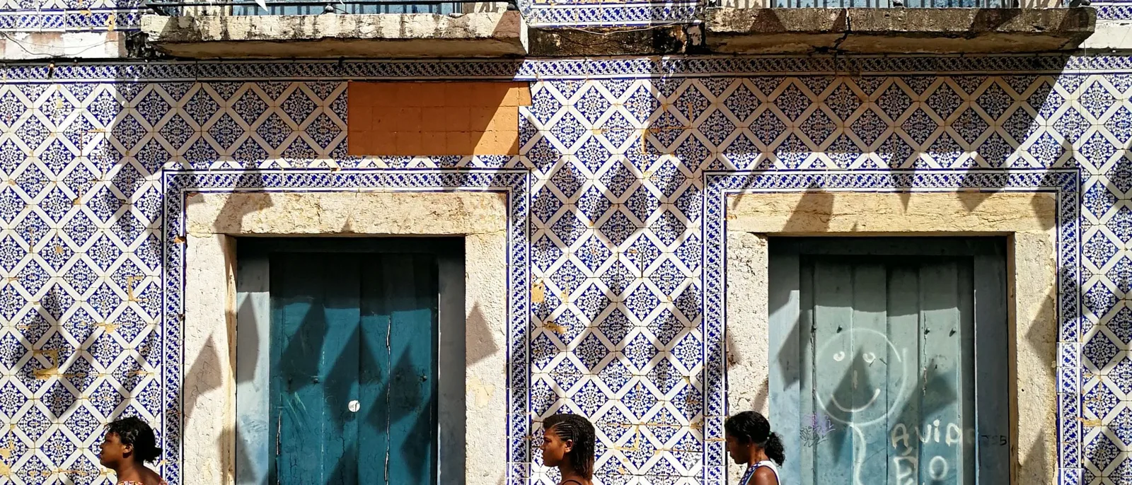 A colonial facade in the historic center of São Luís tiled floor to roof in blue-and-white azulejos, with turquoise doors and June festival bunting strung above