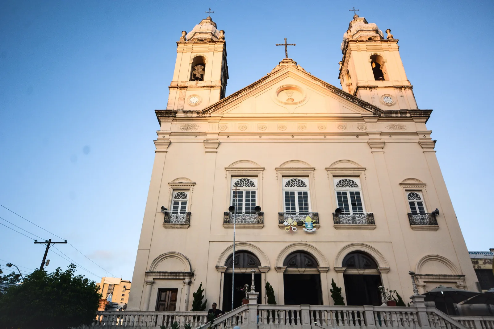 The Catedral Metropolitana of Maceió seen from below: a pale pink neoclassical front with two square bell towers and a cross above the pediment
