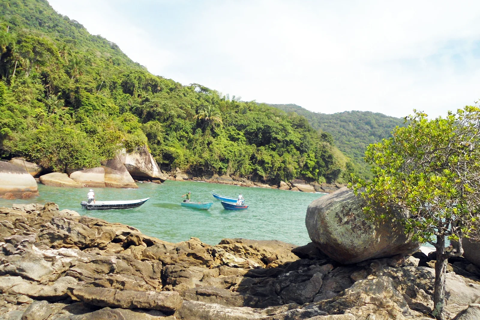A sheltered cove on the Paraty coast seen from the rocks above it, small boats at anchor on clear green water