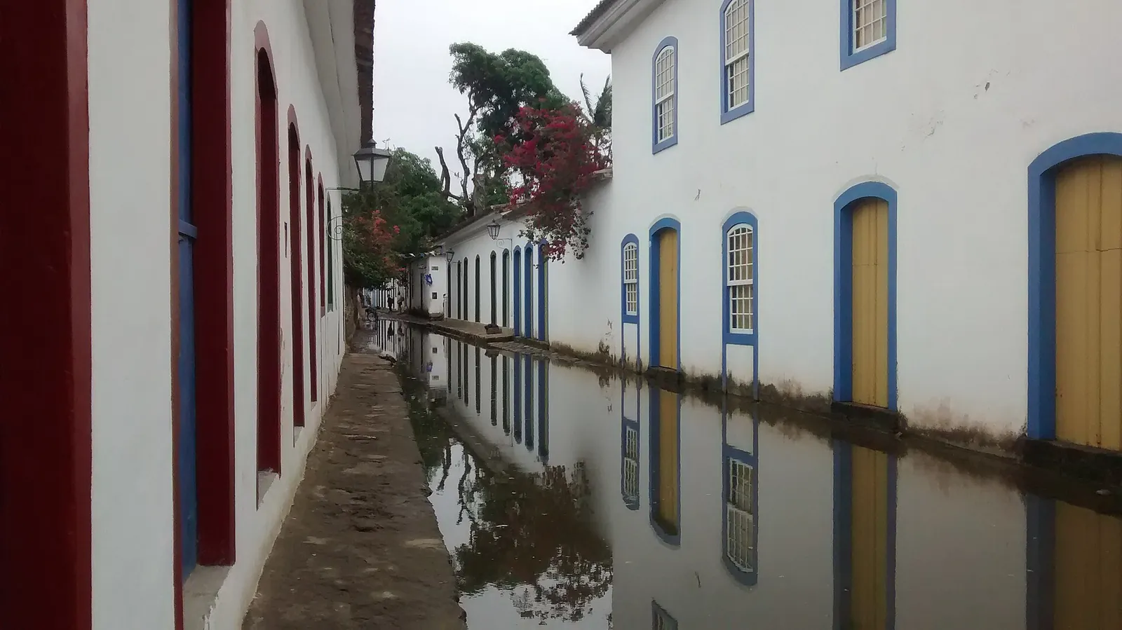A Paraty street flooded by the high tide, reflecting colonial facades