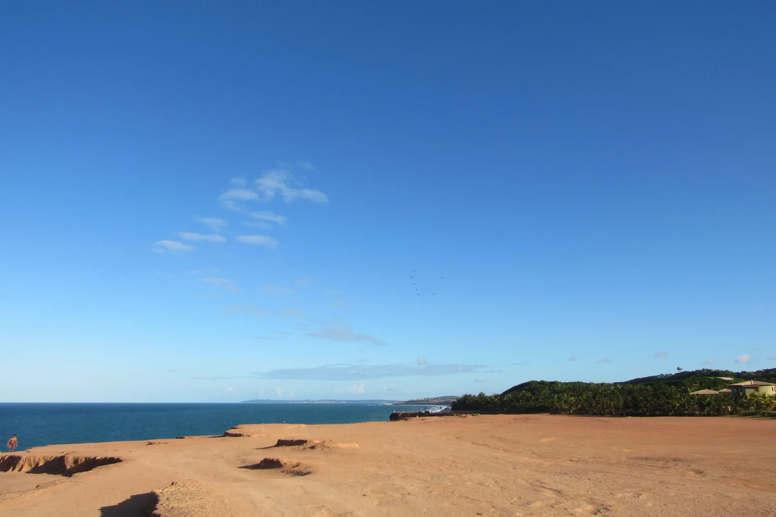 The flat sandy top of the Chapadão running out toward the sea, with bare red rock at the edge and the ocean horizon beyond