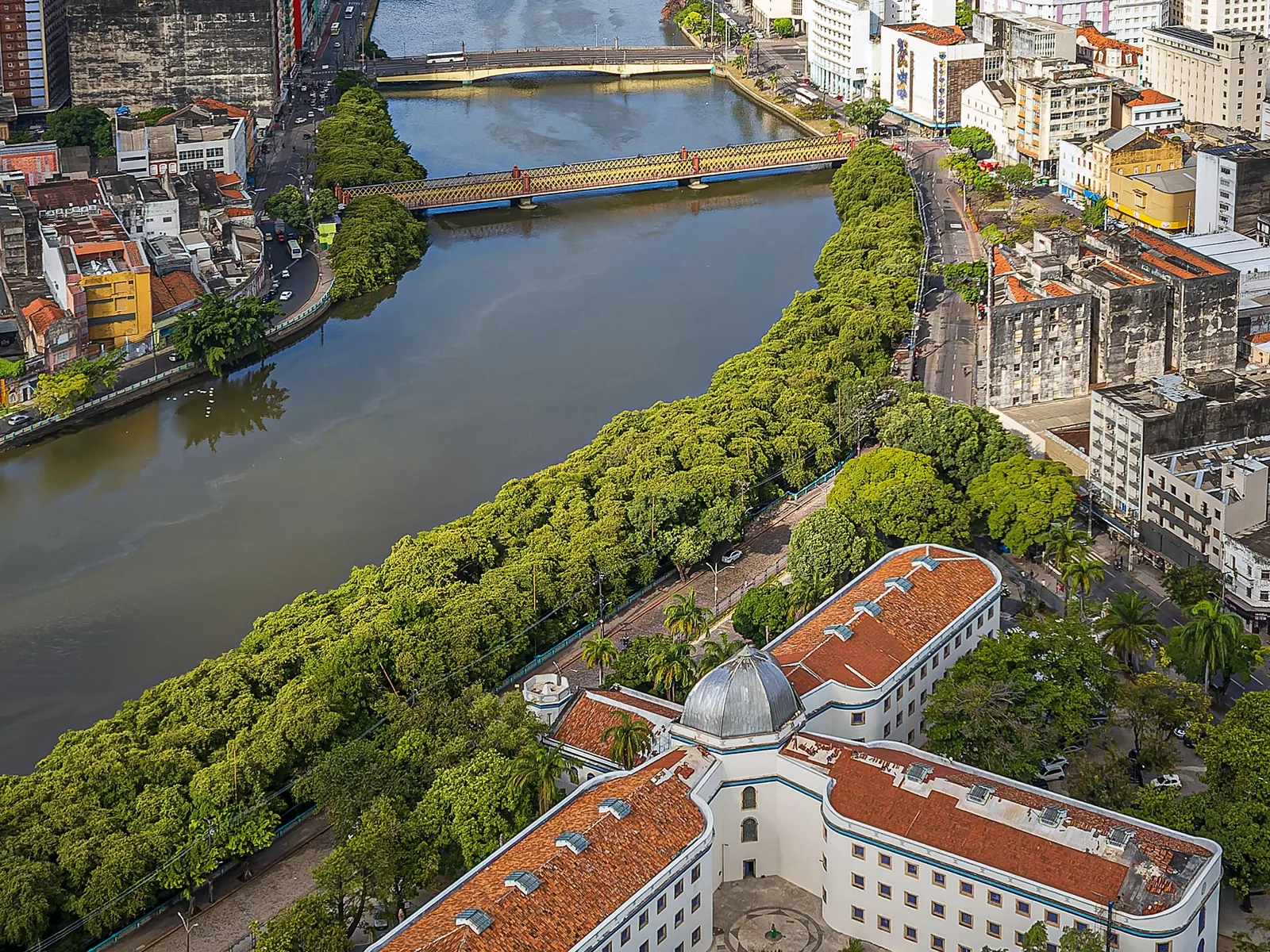 The Capibaribe from the air with its bridges, and the radial nineteenth-century building of the Casa da Cultura among trees on the bank