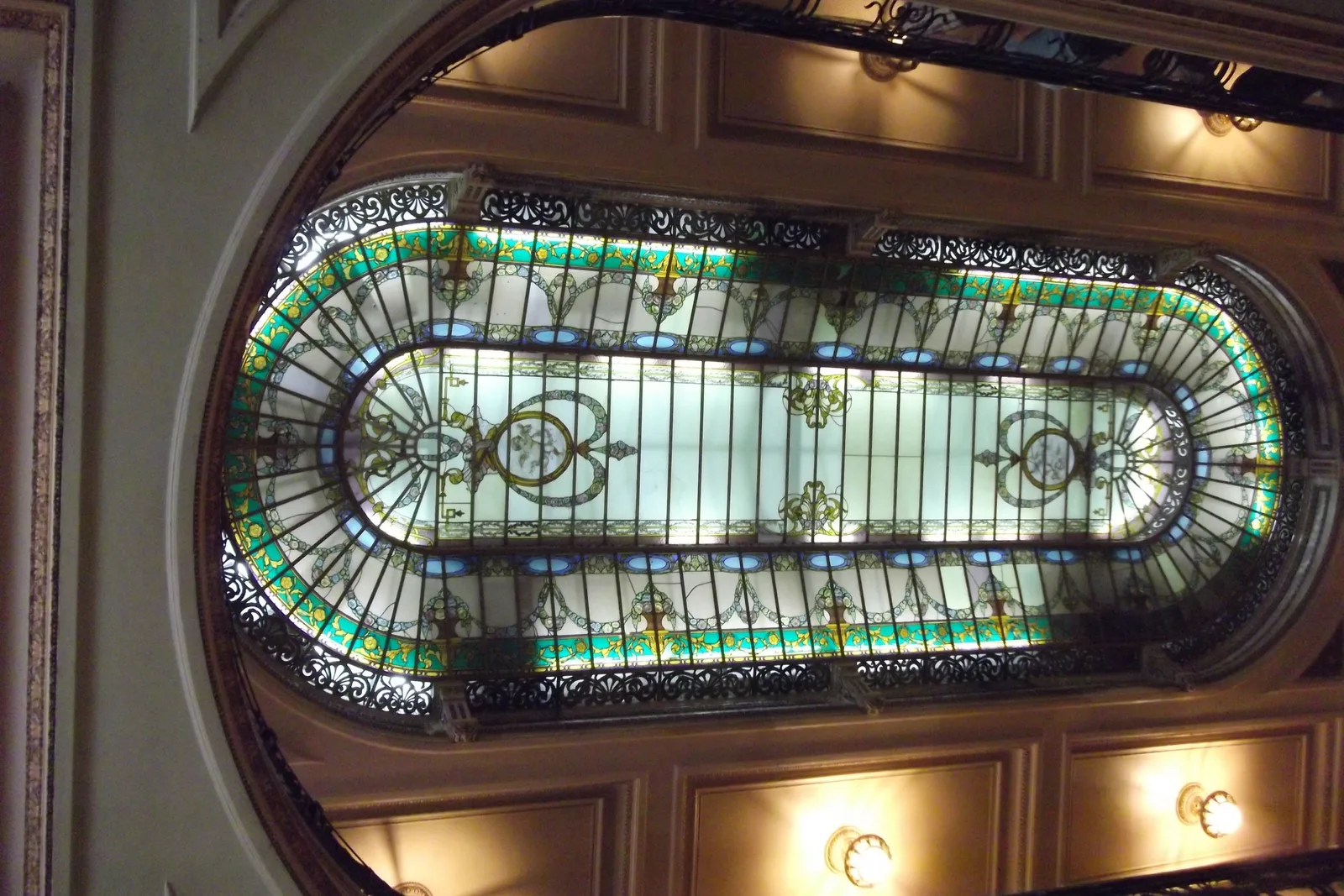 The stained-glass skylight of Confeitaria Colombo seen from the café floor below, set into its ornate painted ceiling