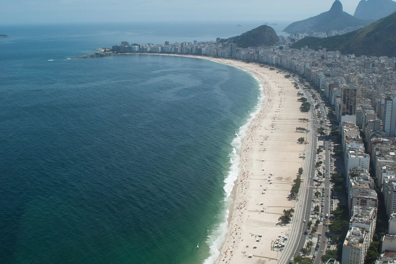 The long curve of Copacabana beach from above, the promenade and its line of buildings following the sand around the bay