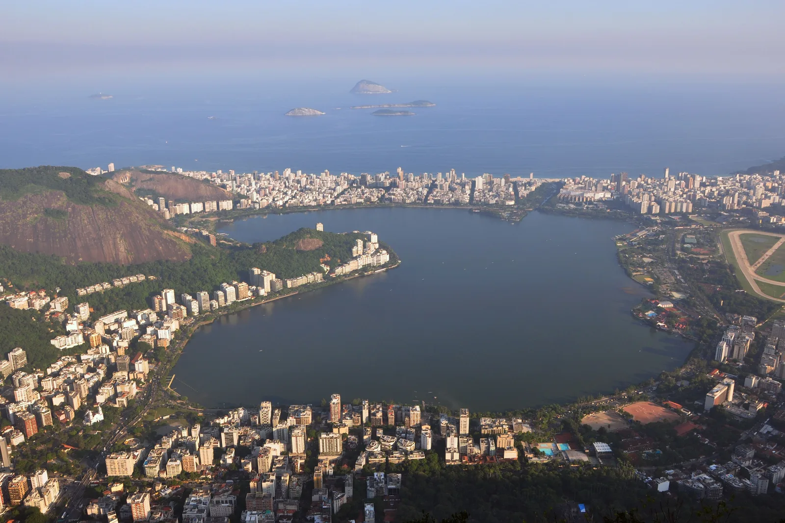 Lagoa Rodrigo de Freitas from above: flat water ringed completely by the city, with the beaches and the Atlantic beyond it