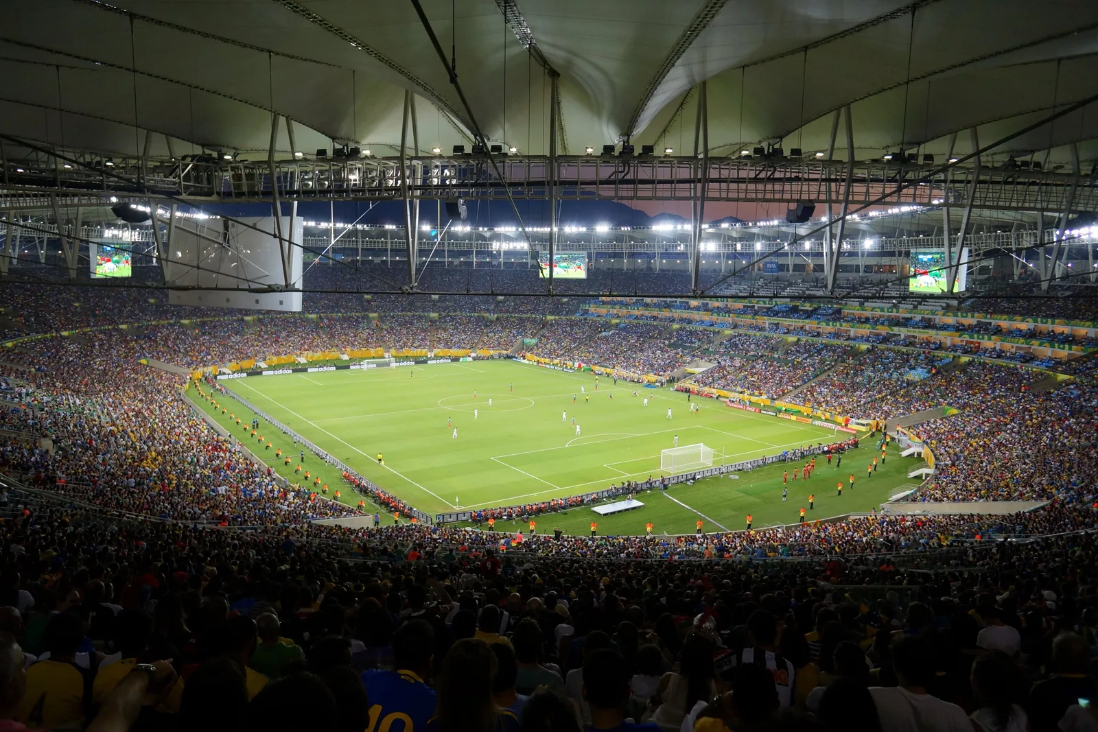 The Maracanã at night from high in the stands, the floodlit pitch below and every tier packed with supporters