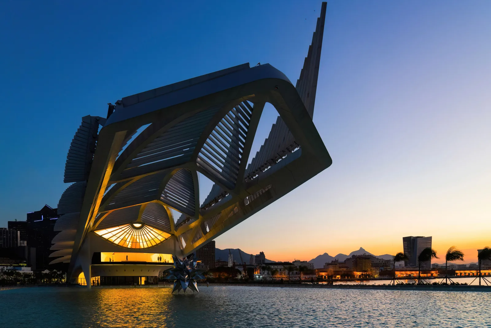 The Museum of Tomorrow at sunset, its long cantilevered roof reaching out over the water of the old port