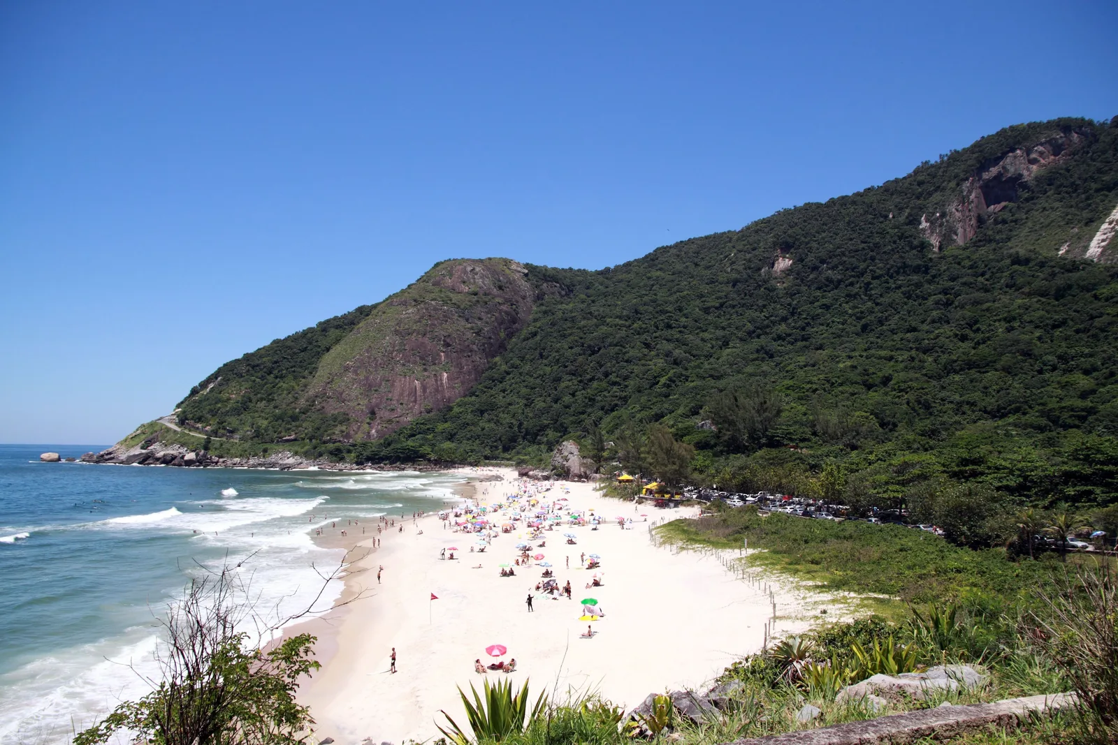 The small cove of Prainha seen from the headland above, forested hills running down to the sand and no buildings anywhere on it