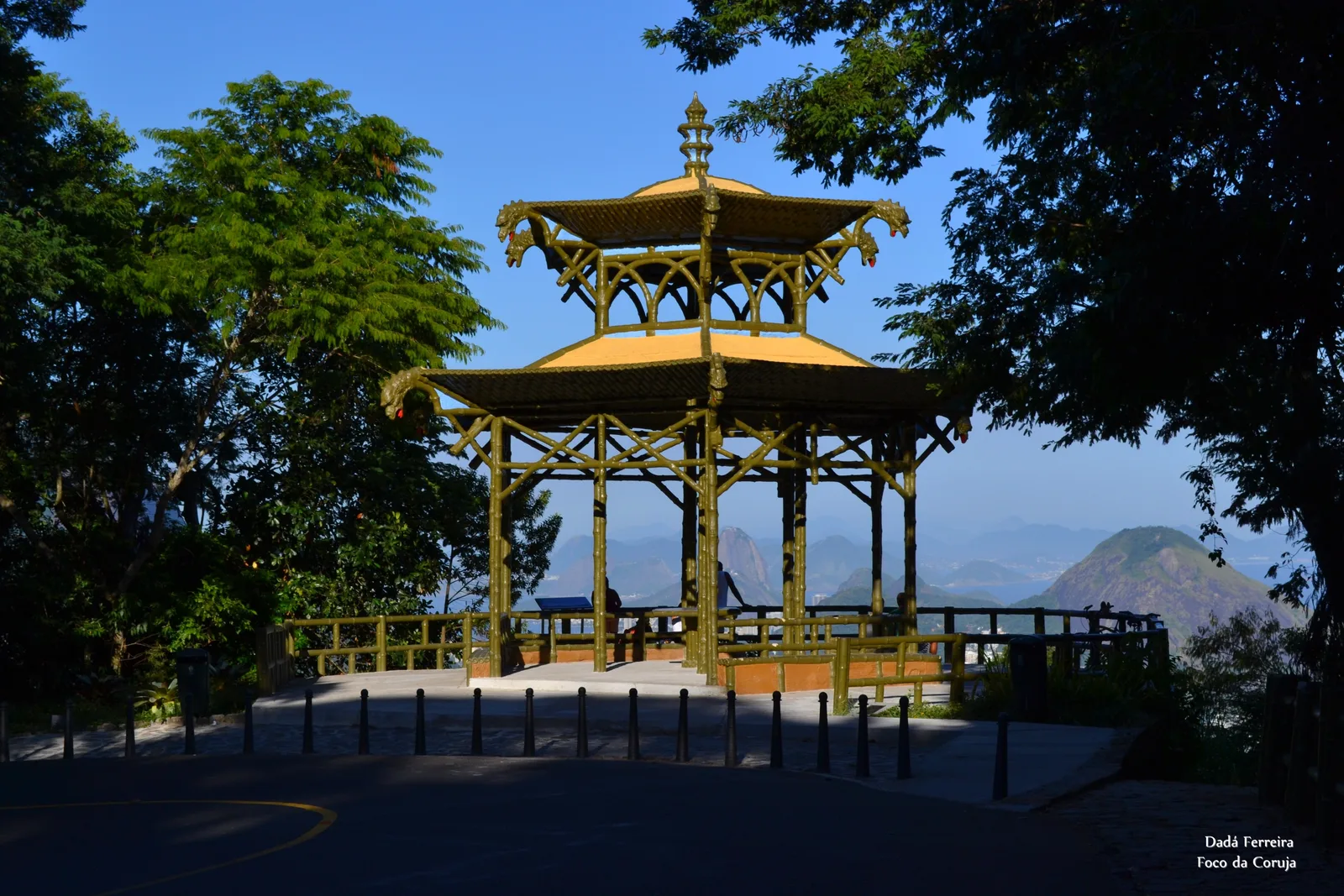 The pagoda-roofed Vista Chinesa pavilion at dusk, lit against the trees with the city below beyond its railing