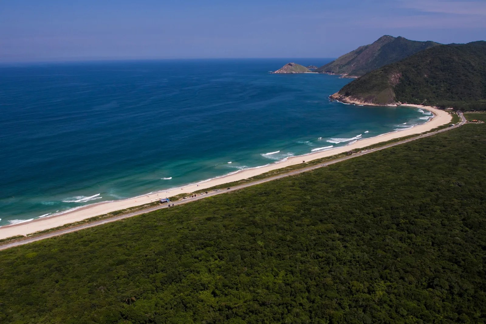Grumari from the air: a long empty beach curving between green hills and deep blue sea on Rio’s wild west side