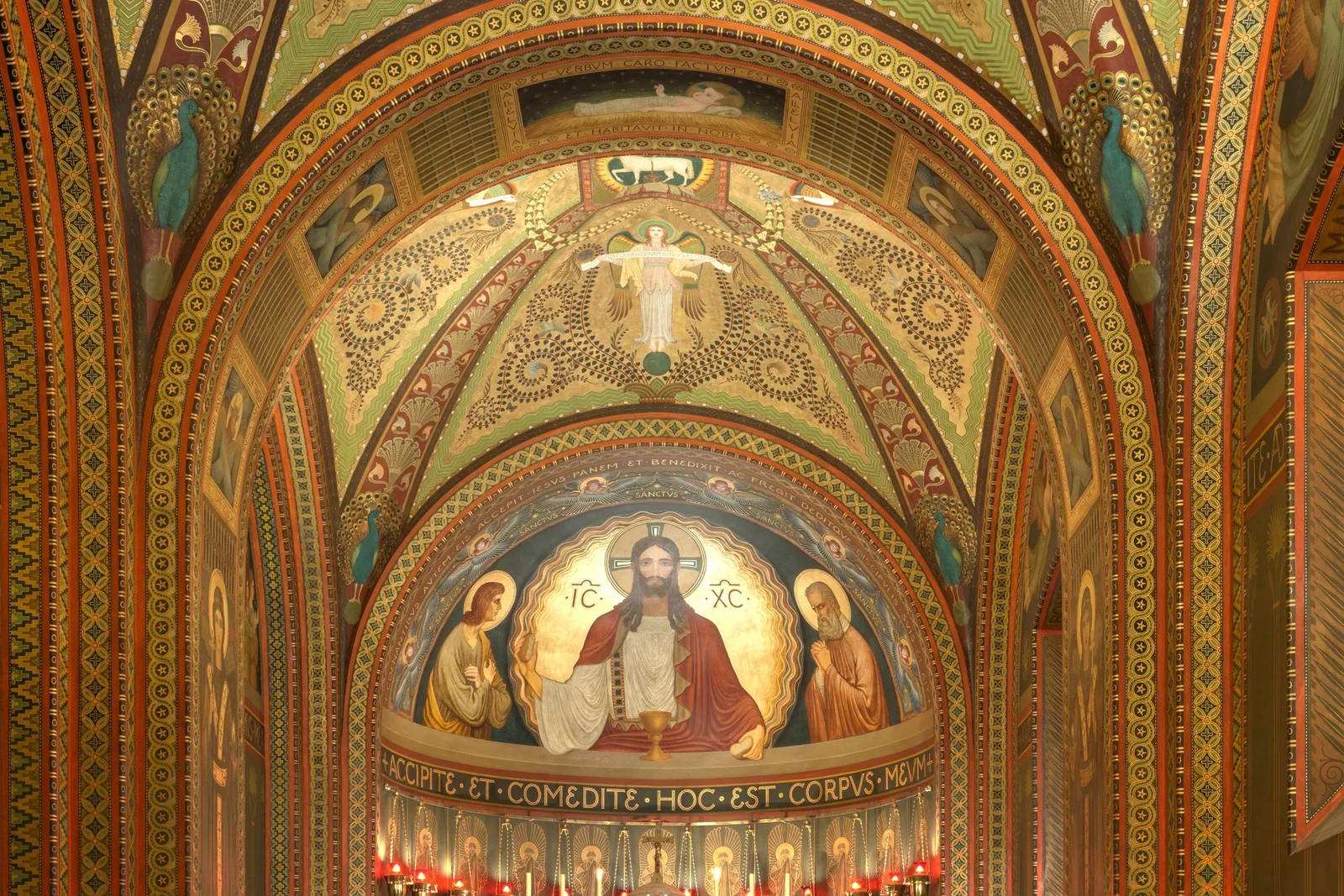 The apse of the Mosteiro de São Bento: a gilded half-dome covered in mosaic and painted ornament, with a large mosaic of Christ enthroned between angels above the high altar