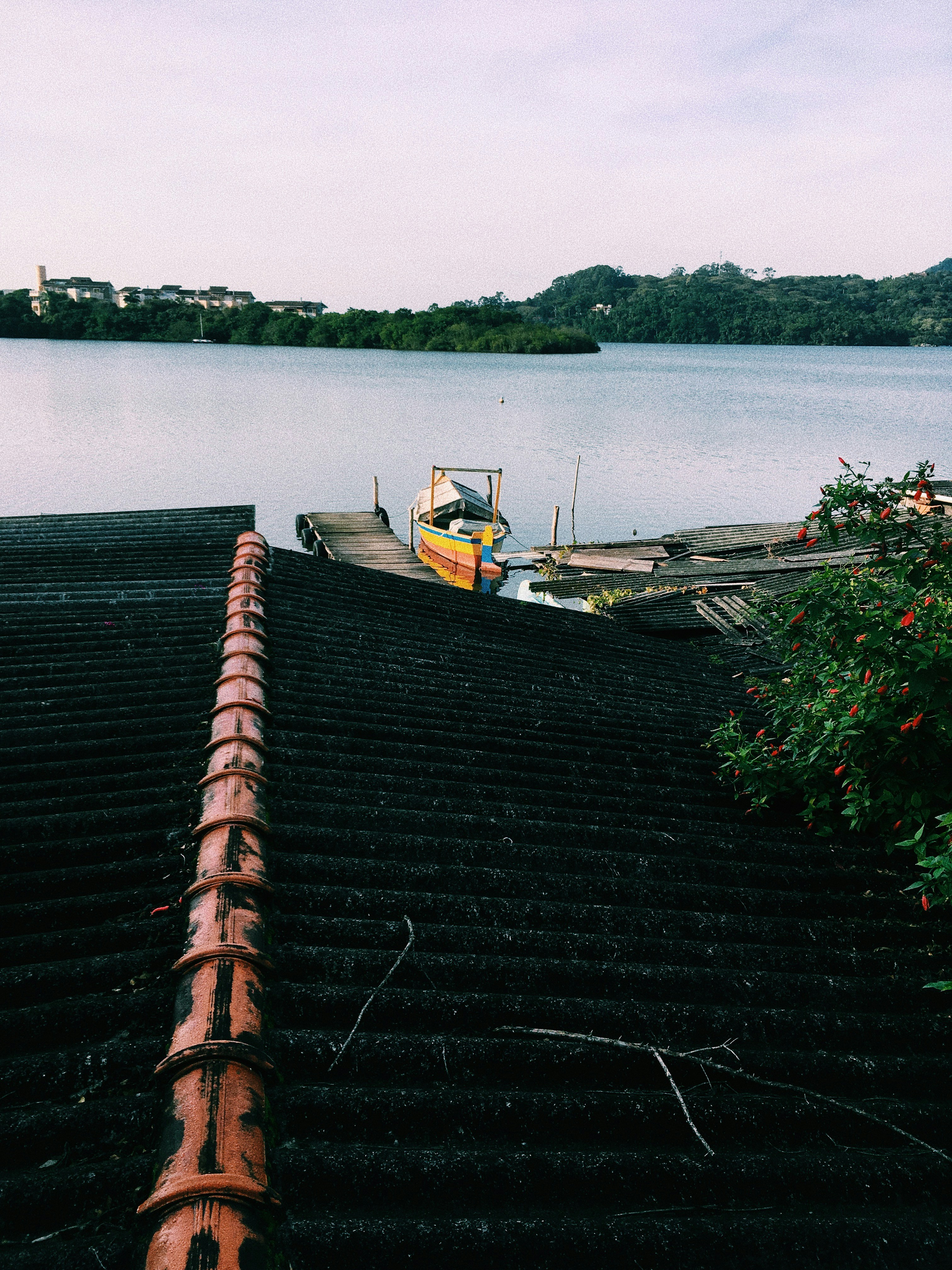 A canoe on the calm water of Lagoa da Conceição with the surrounding hills behind